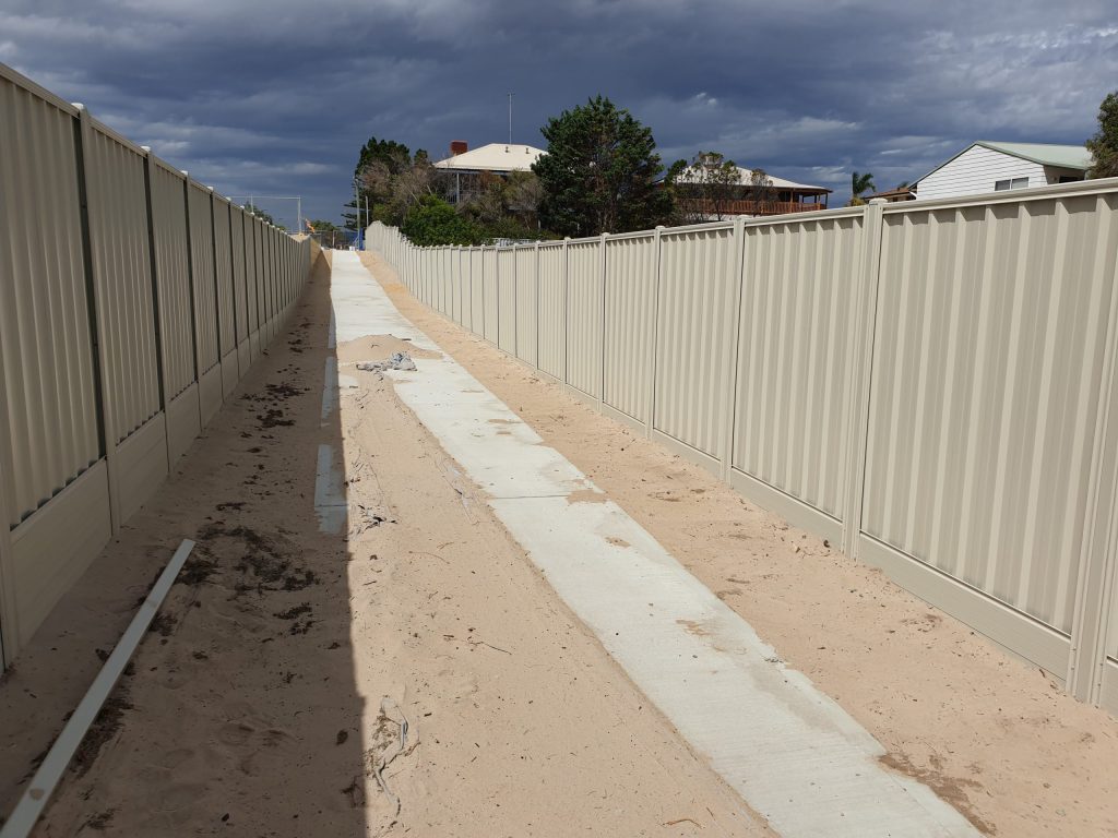Colorbond fencing on both sides of a sidewalk