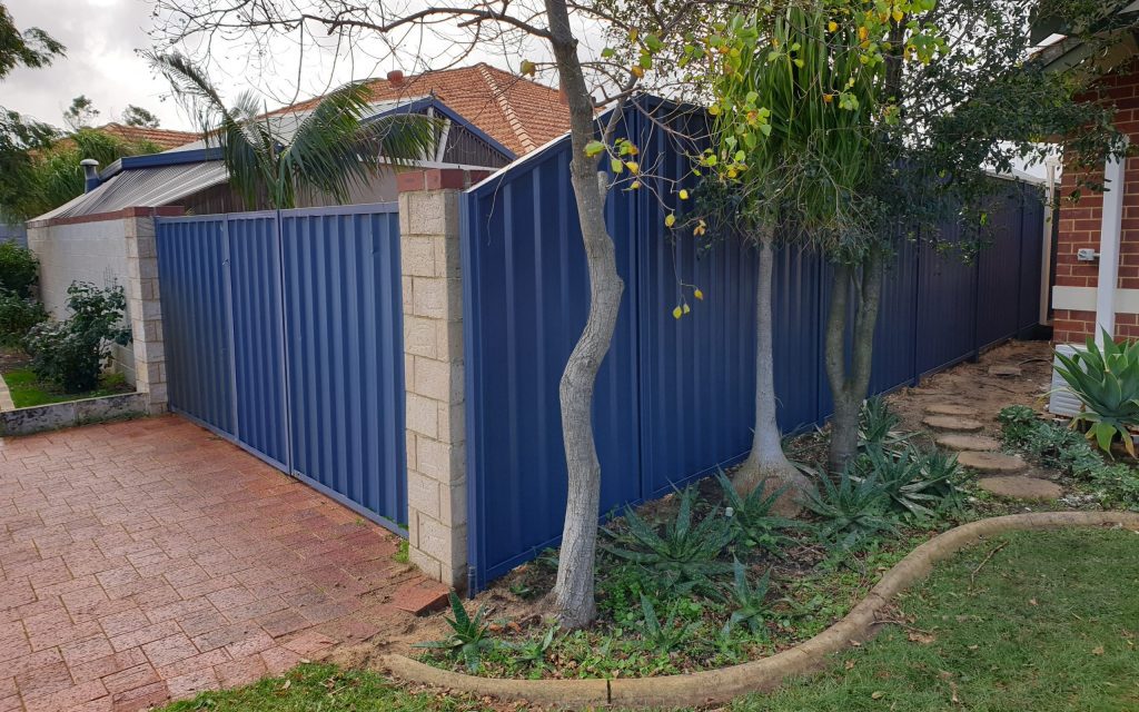 A blue colobond fence installed by fencing contractors.