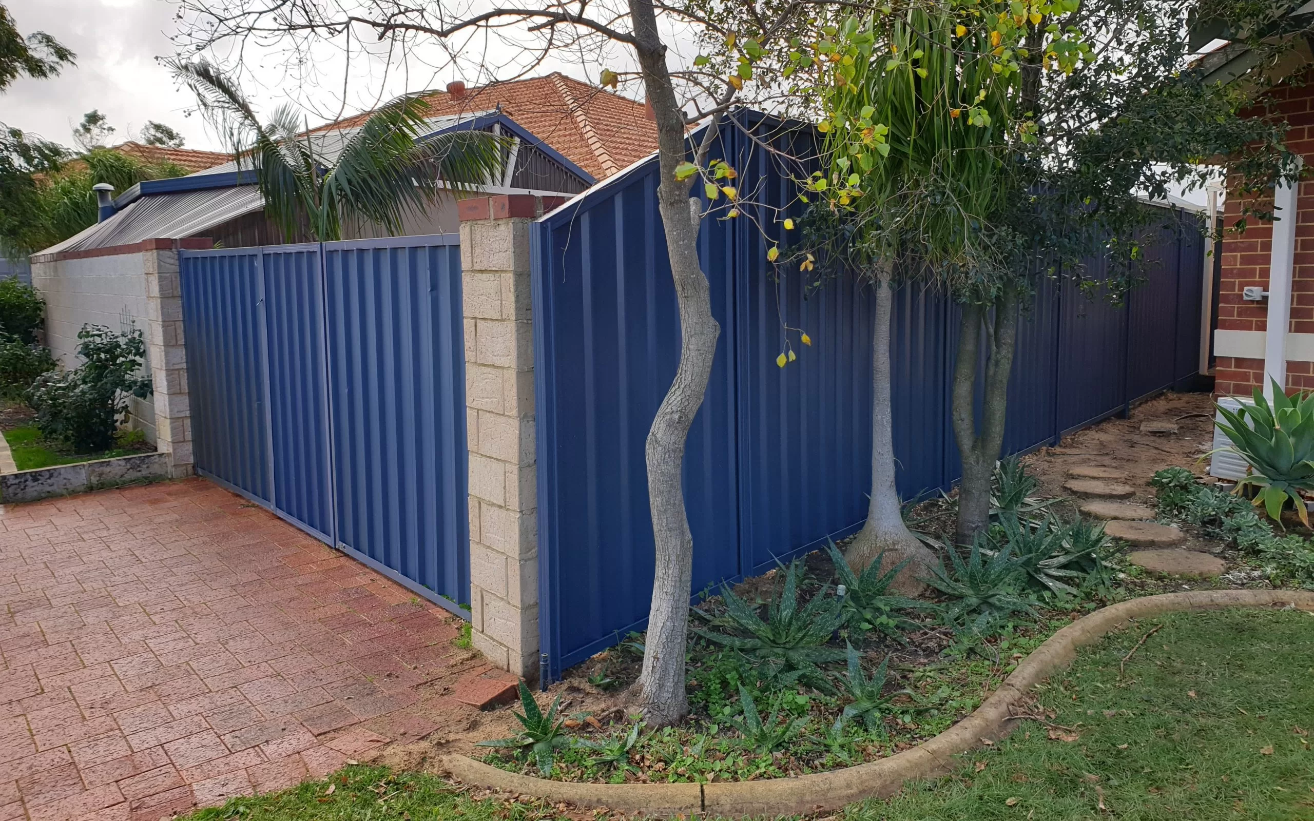 A blue colobond fence installed by fencing contractors.