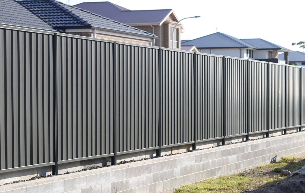 Black colorbond fence on retaining wall.